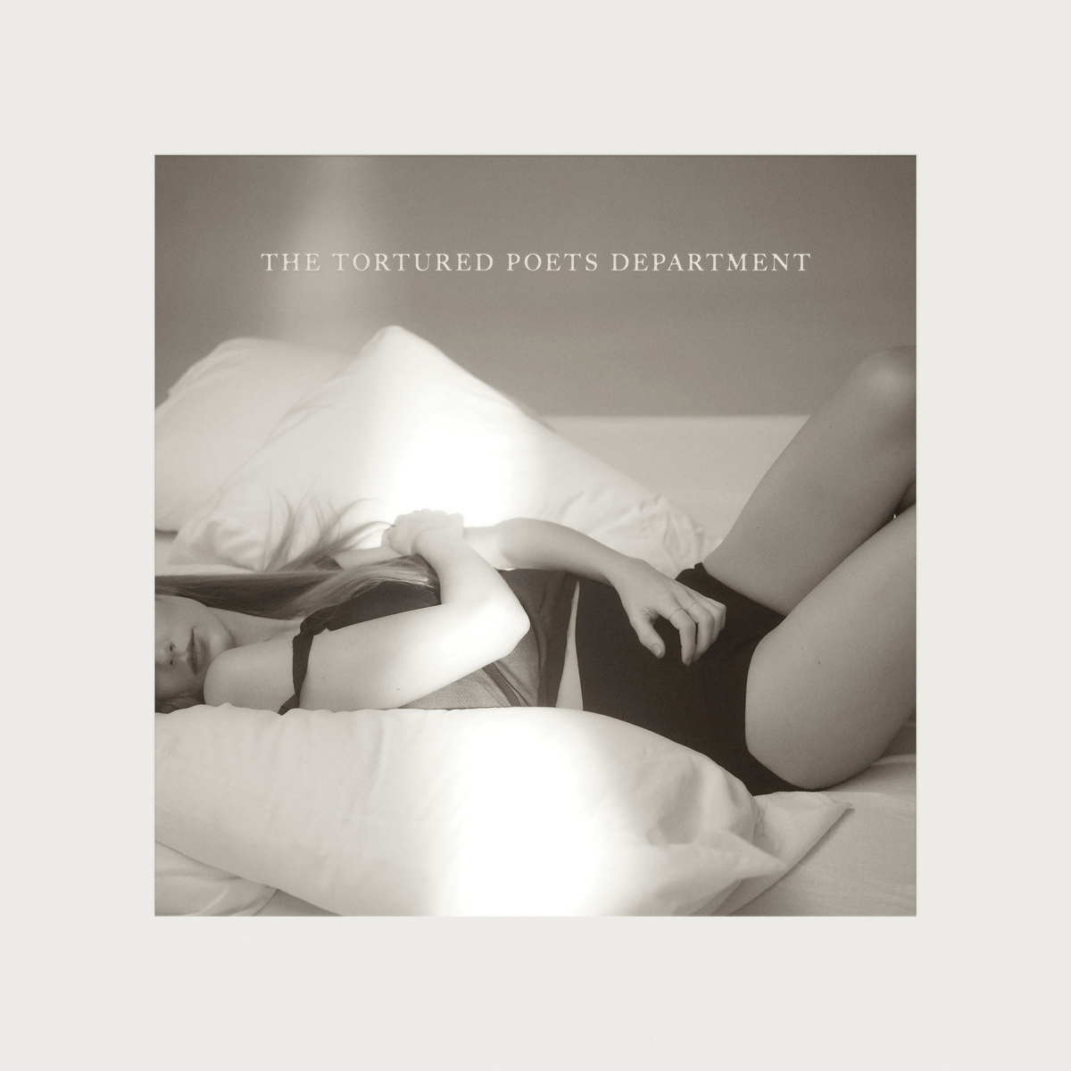 Album cover showing person lying on bed, titled "The Tortured Poets Department"