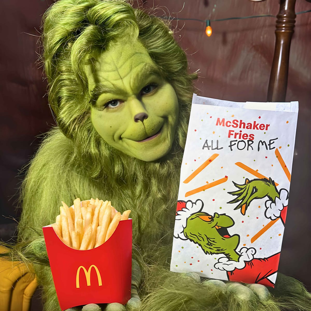 The Grinch holds McDonald's fries and a McShaker bag