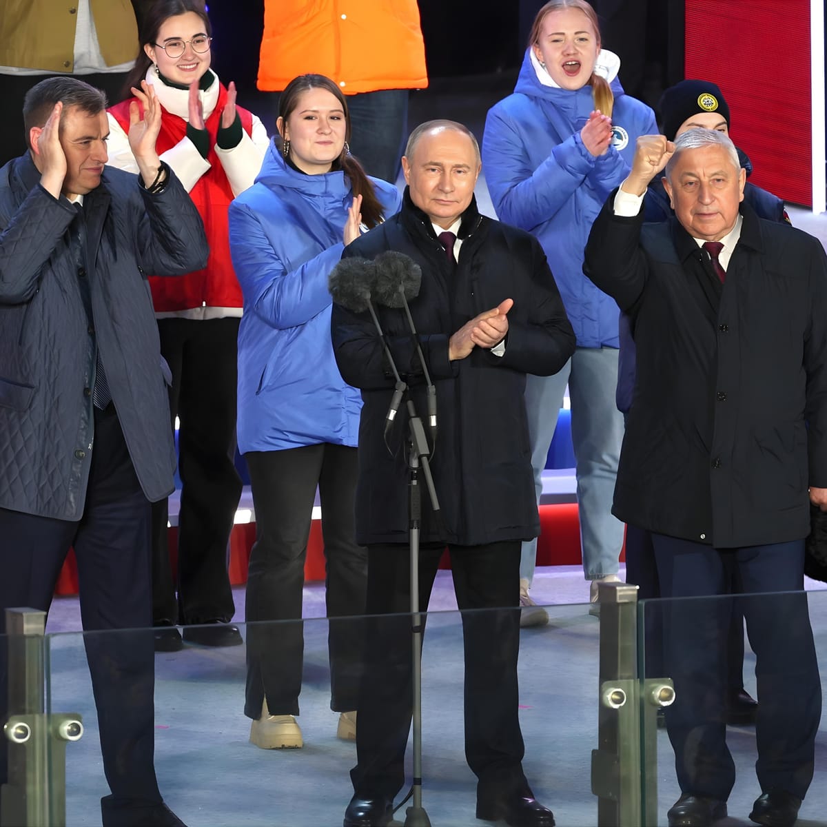 Russian presidential candidates applaud together on stage after the election results